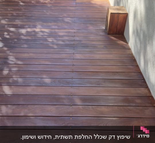דק עץ חום עם צללים ועצים ברקע